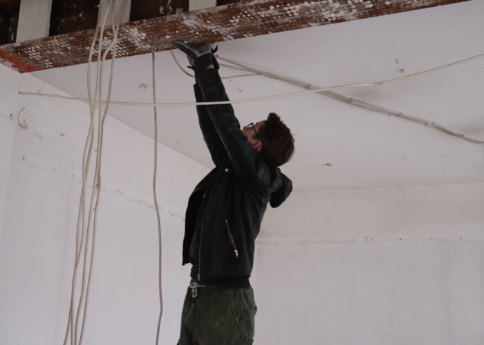 Die Jugendlichen Entfernen die Kabel der Decke im kleinen Veranstaltungsraum.